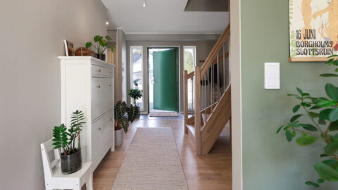 Eingangsbereich mit grüngestrichener Wand und grüner Tür in Haus von Eksjöhus