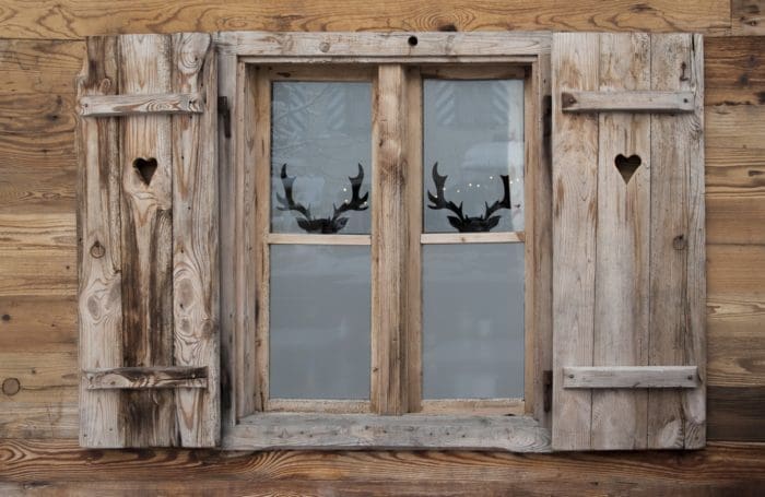 Fenster am alpinen Holzhaus mit Fensterläden