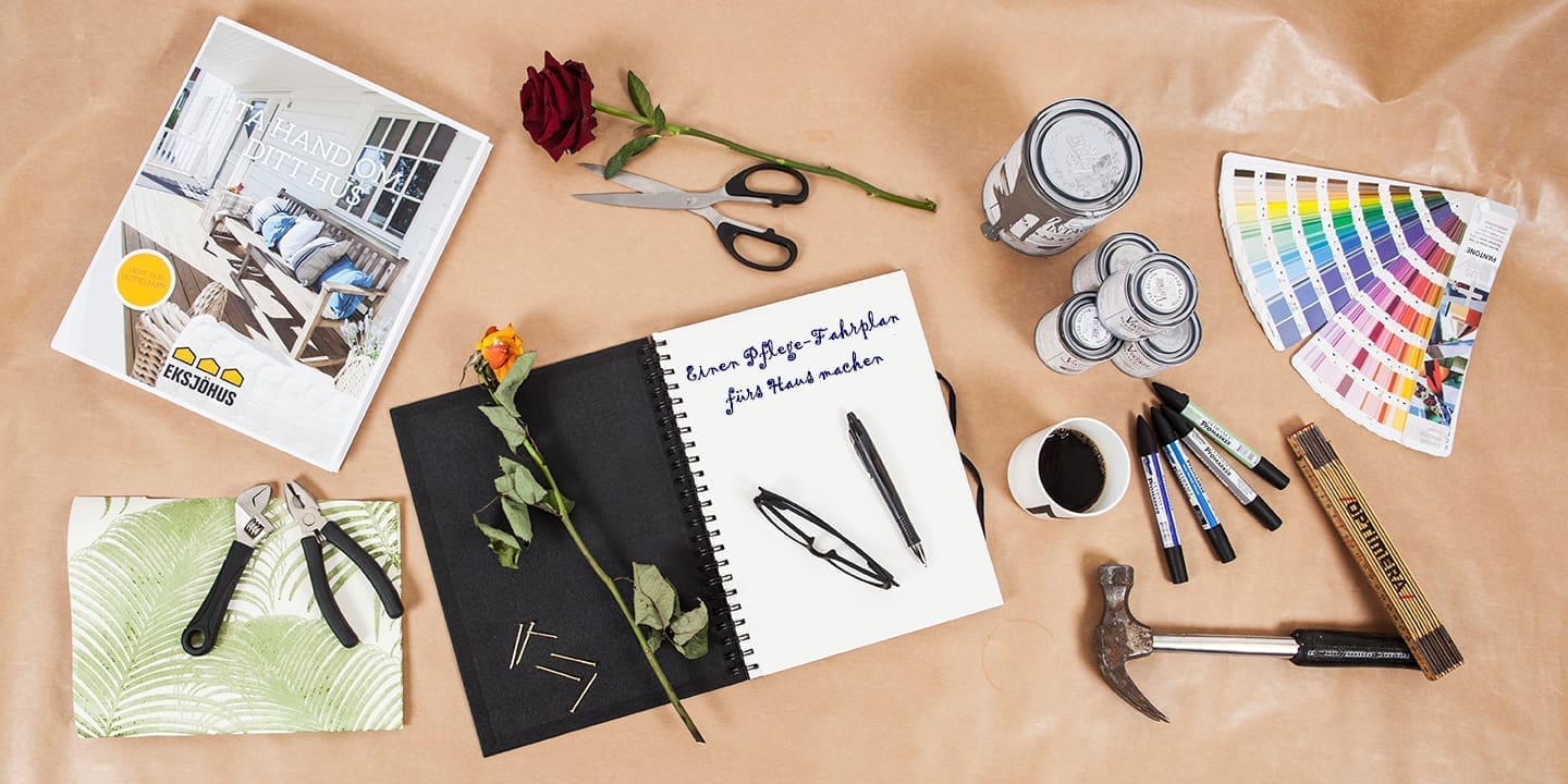 Werkzeuge und Planungsutensilien für Hausrenovierung auf Schreibtischplatte