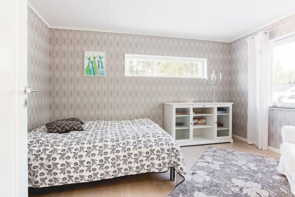 Schlafzimmer im skandinavischen Stil mit grauer Mustertapete
