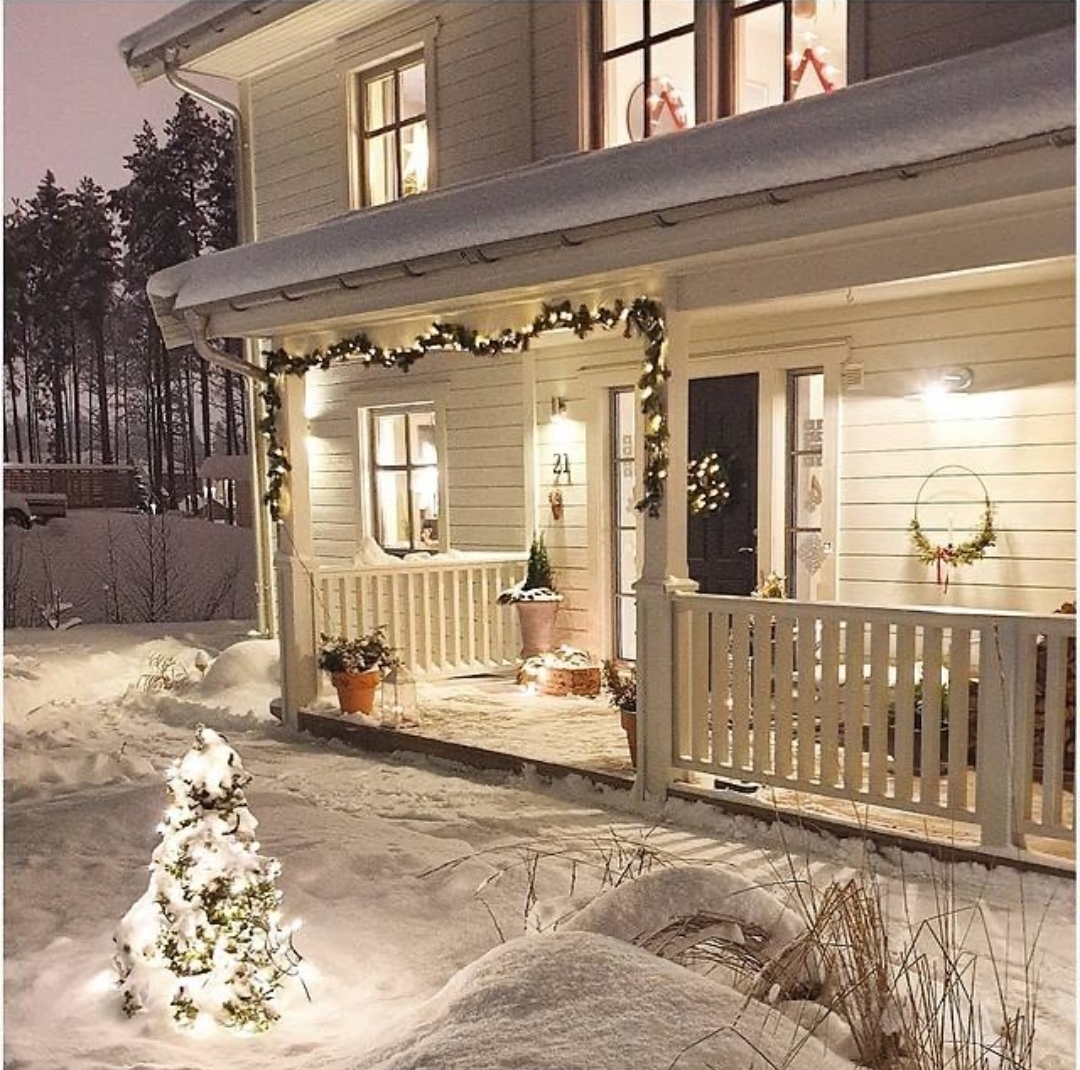 Schwedenhaus jn Weihnachtsstimmung: weißes Haus von Eksjöhus mit Lichterkette in verschneiter Landschaft