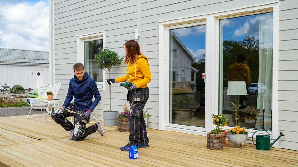 Hausbesitzer-Paar bei Arbeiten an der Terrasse zum Schwedenhaus