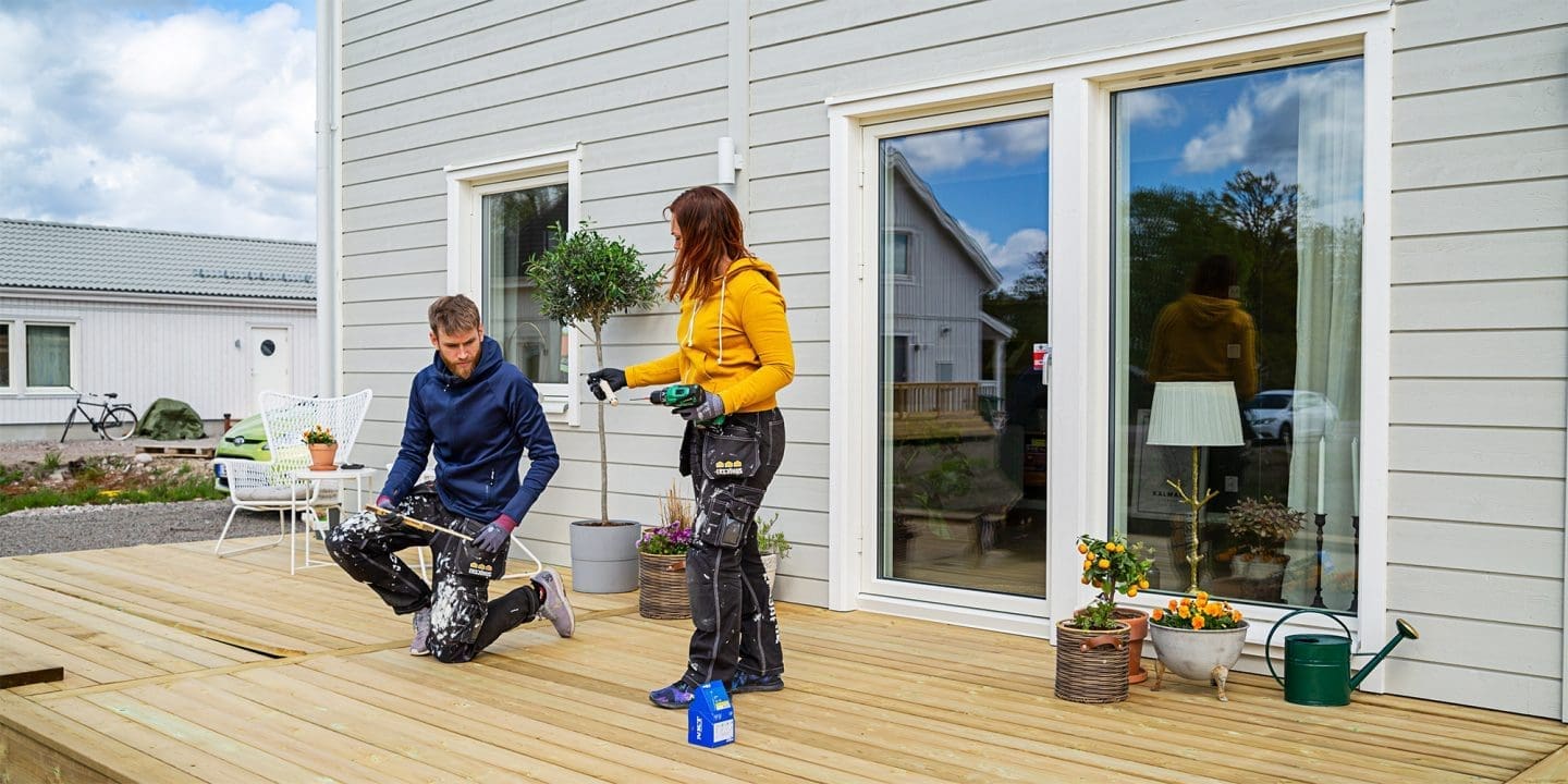 Hausbesitzer-Paar bei Arbeiten an der Terrasse zum Schwedenhaus