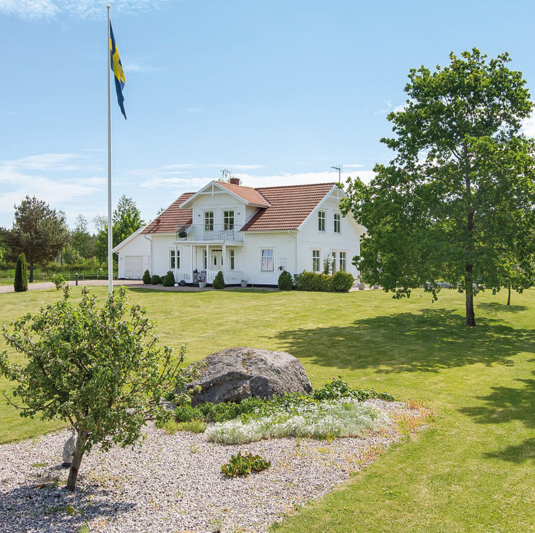 Eksjöhus-Haus Balans mit Schwedenflagge im Vordergrund