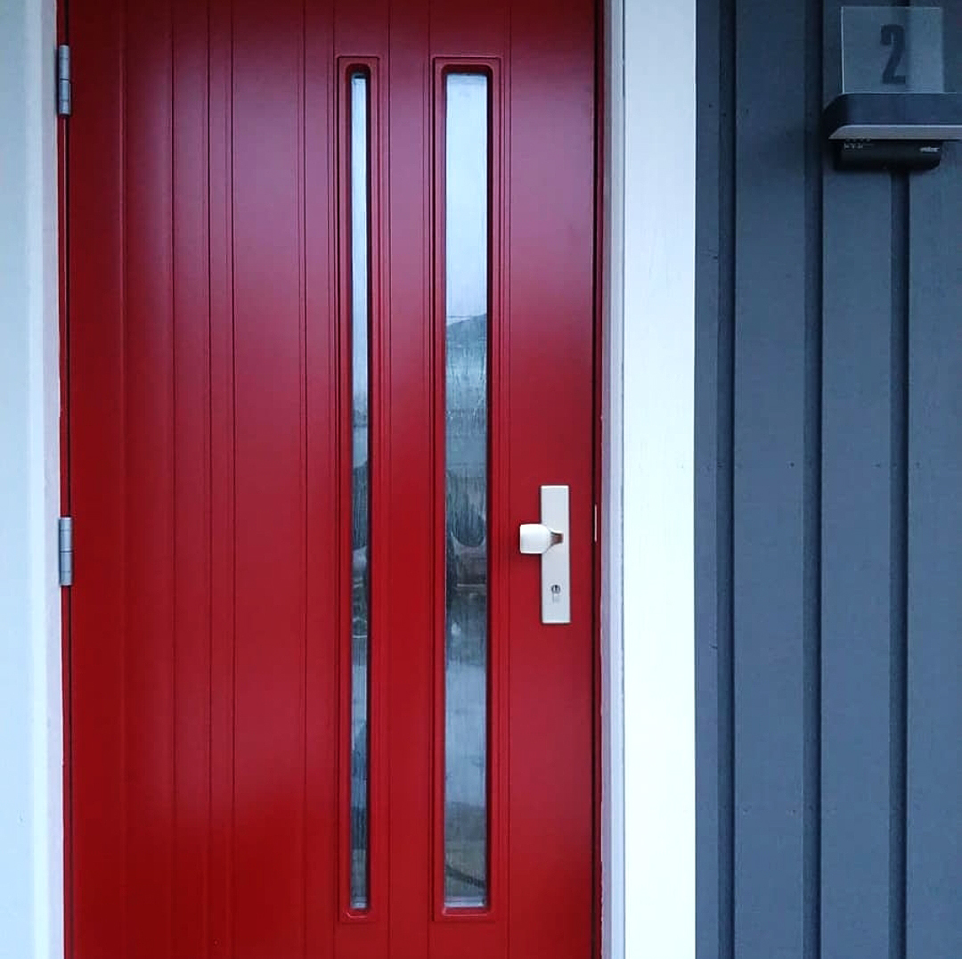 Dunkelgraues Tidö mit roter Tür von Eksjöhus